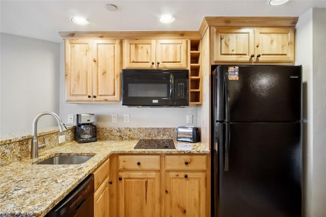 kitchen featuring sink, light stone counters, black appliances, light brown cabinetry, and kitchen peninsula