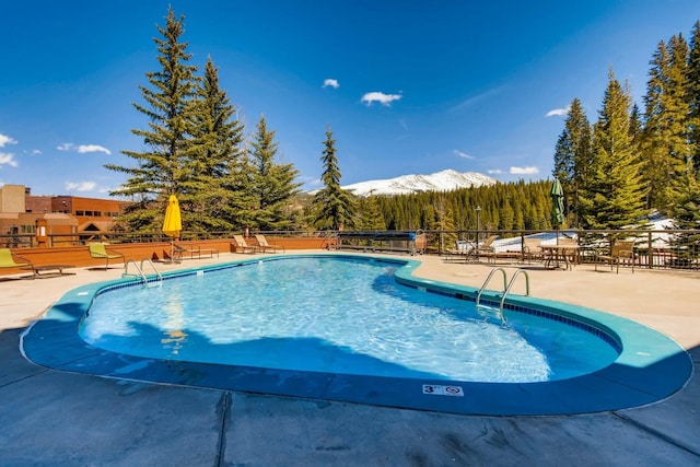 view of pool with a mountain view and a patio area