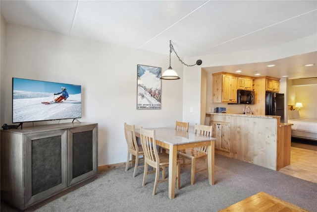 carpeted dining area featuring sink