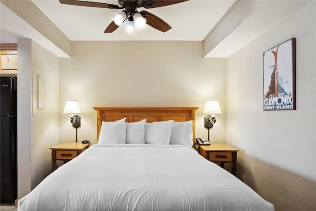 bedroom with ceiling fan and black fridge