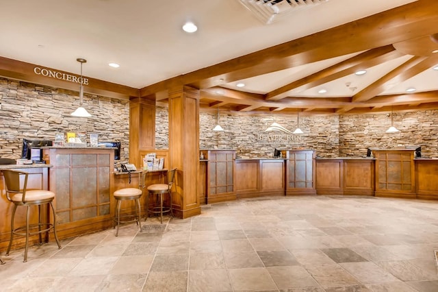 bar featuring beam ceiling, decorative light fixtures, and light stone countertops