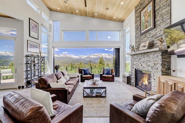 living room with a mountain view, a towering ceiling, a fireplace, and wooden ceiling