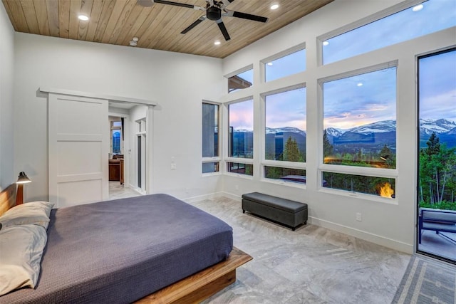 bedroom with a mountain view, ceiling fan, and wooden ceiling