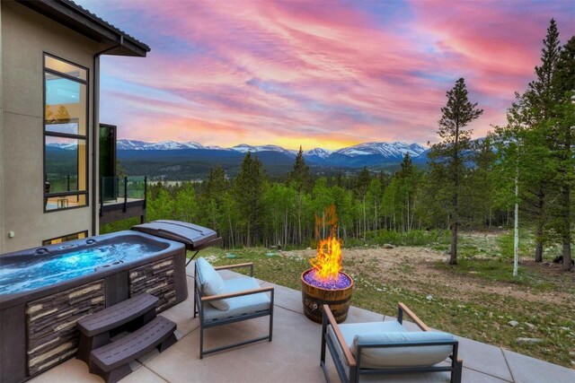 patio terrace at dusk featuring a mountain view