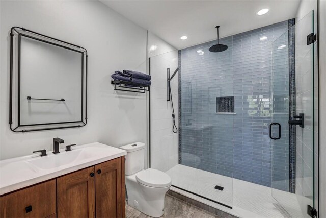 bathroom with vanity, toilet, and an enclosed shower