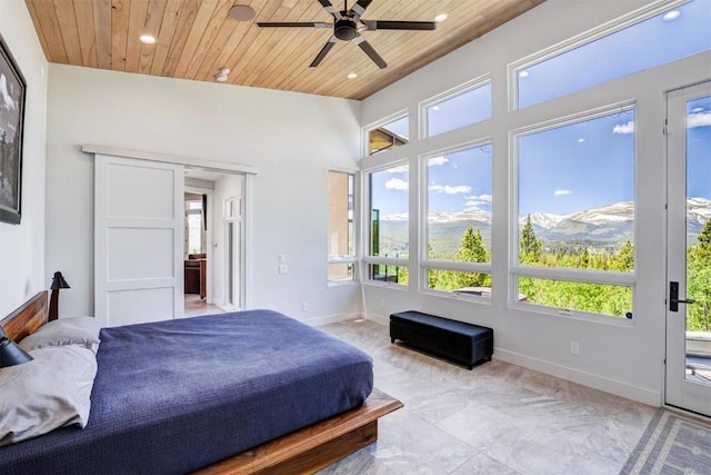 bedroom with ceiling fan, a mountain view, and wooden ceiling