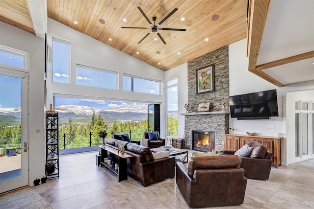 living room with ceiling fan, high vaulted ceiling, a mountain view, a fireplace, and wood ceiling