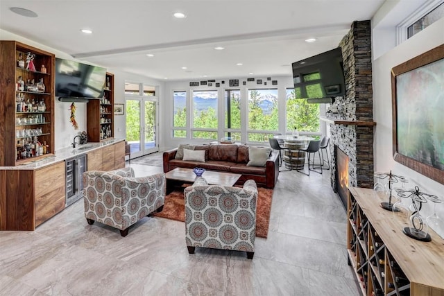 living room with bar, wine cooler, a fireplace, and french doors