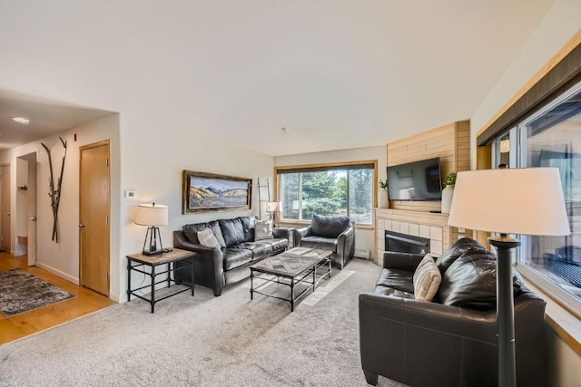 living room featuring carpet floors and a tile fireplace