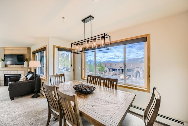 carpeted dining room with a fireplace and baseboard heating