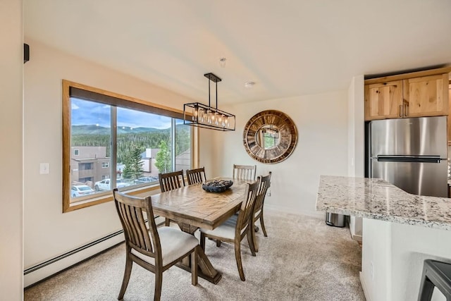 dining space with baseboards, a baseboard heating unit, and light colored carpet