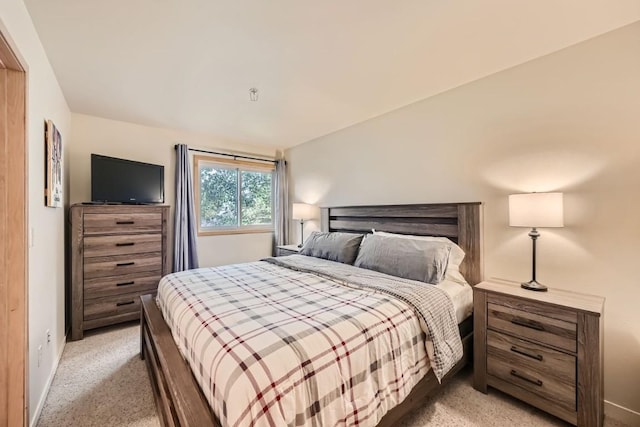 bedroom with light carpet and vaulted ceiling