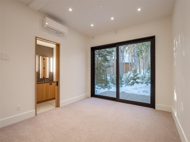 empty room with light colored carpet, sink, and a wall unit AC