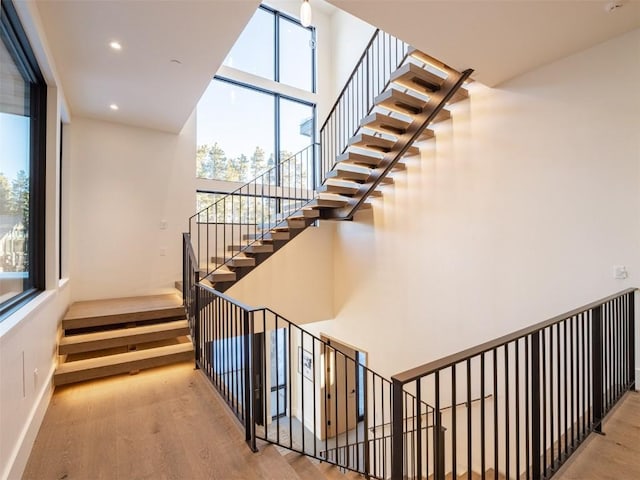 staircase featuring hardwood / wood-style floors and plenty of natural light