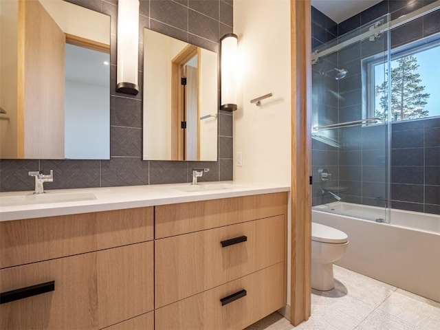 full bathroom with combined bath / shower with glass door, backsplash, vanity, tile patterned flooring, and toilet