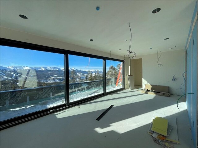 unfurnished room featuring concrete floors and a mountain view