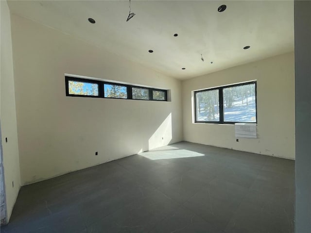 unfurnished room with vaulted ceiling