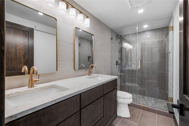 bathroom featuring tile patterned floors, vanity, toilet, and a shower with shower door