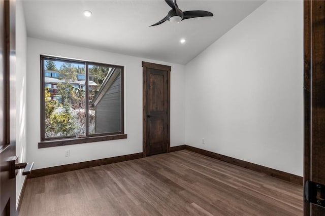 unfurnished room with dark hardwood / wood-style flooring, vaulted ceiling, and ceiling fan