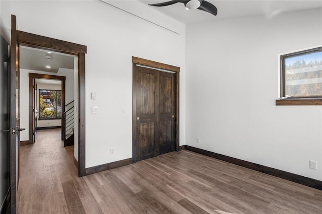 unfurnished bedroom with hardwood / wood-style flooring, a closet, and ceiling fan