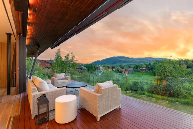 deck at dusk with a mountain view and outdoor lounge area