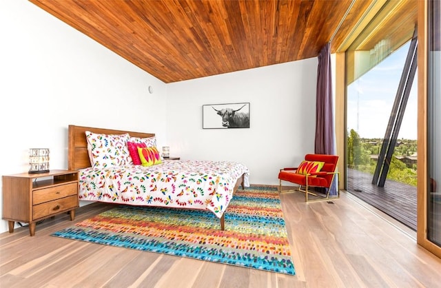 bedroom with multiple windows, hardwood / wood-style floors, wooden ceiling, and lofted ceiling