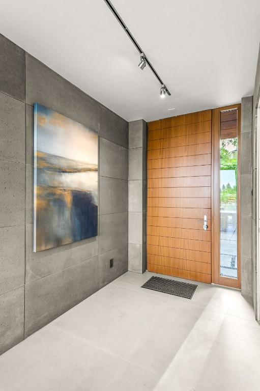 empty room featuring concrete flooring and rail lighting