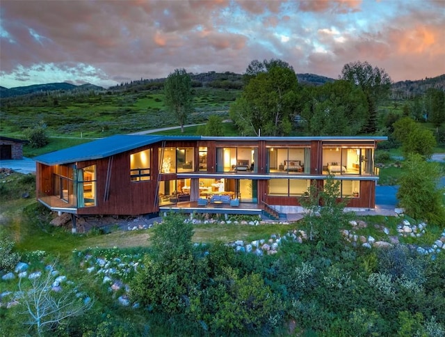 back of property at dusk featuring a mountain view