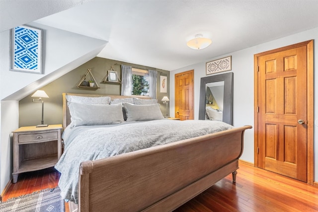 bedroom with lofted ceiling and hardwood / wood-style flooring