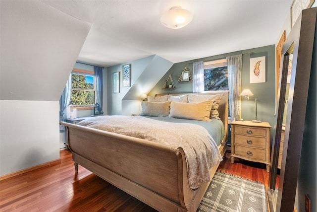 bedroom with vaulted ceiling and dark hardwood / wood-style flooring