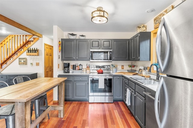 kitchen featuring sink, gray cabinets, dark hardwood / wood-style floors, and appliances with stainless steel finishes