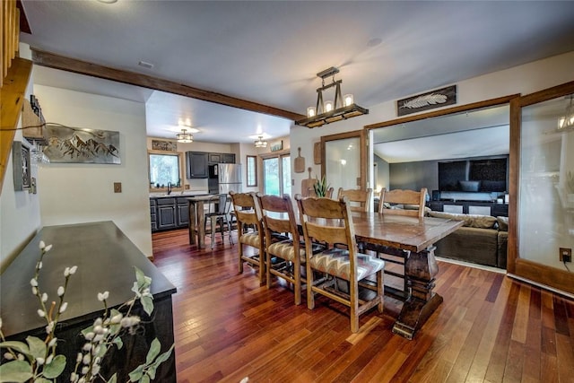 dining space with dark wood-type flooring, sink, and beam ceiling