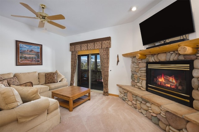 carpeted living room with a fireplace and ceiling fan