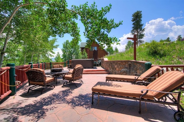 view of patio / terrace featuring a fire pit and a hot tub