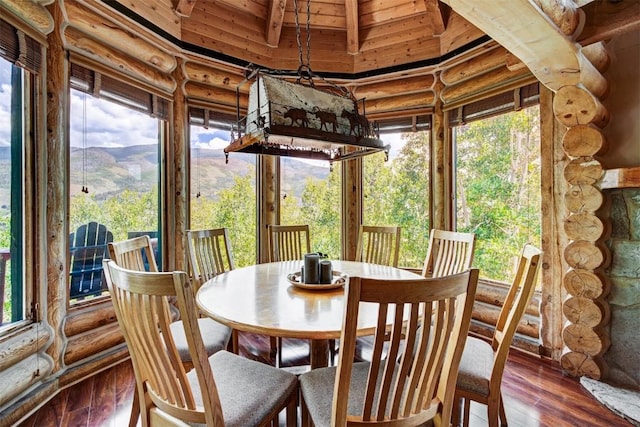 sunroom / solarium featuring a mountain view, lofted ceiling, and wood ceiling