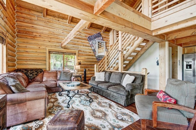 living room with wood-type flooring, rustic walls, and beam ceiling