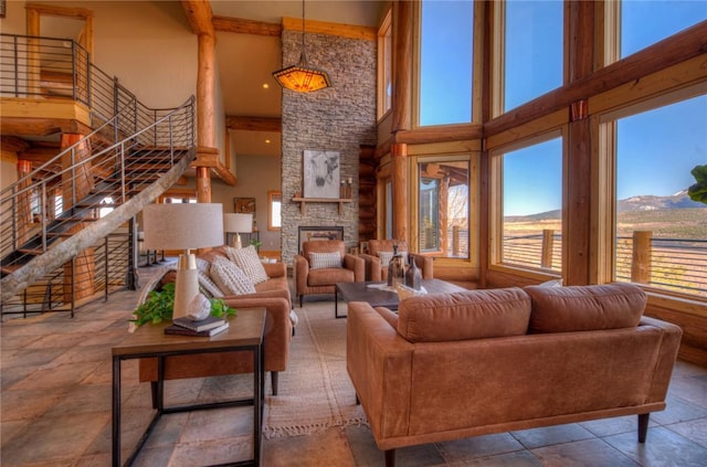 living room with beam ceiling, a mountain view, a fireplace, and a high ceiling