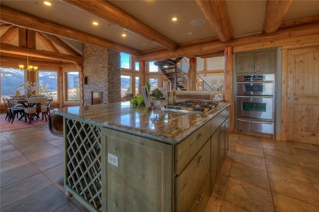 kitchen featuring stainless steel appliances, a kitchen island, plenty of natural light, and a stone fireplace