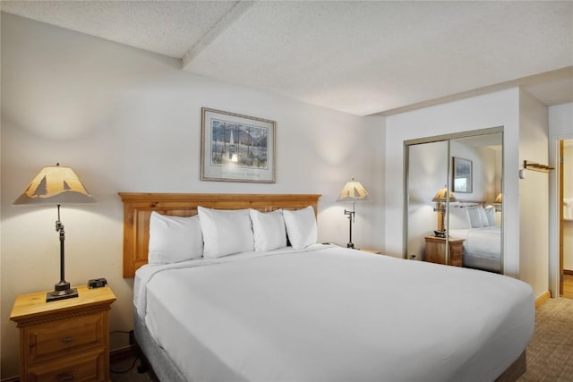 carpeted bedroom with a textured ceiling and a closet