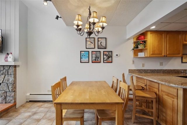 dining room featuring a textured ceiling, a fireplace, a baseboard radiator, and a chandelier