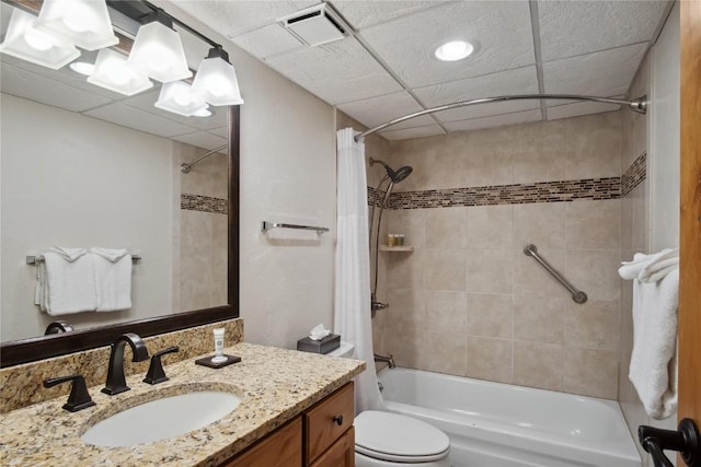 full bathroom featuring vanity, shower / bath combination with curtain, toilet, and a drop ceiling