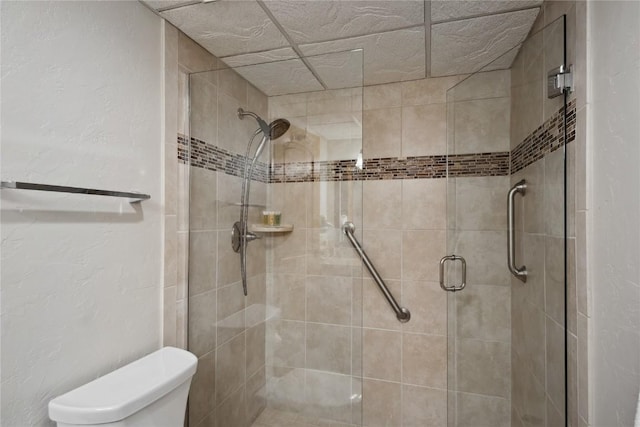 bathroom with a shower with shower door and toilet