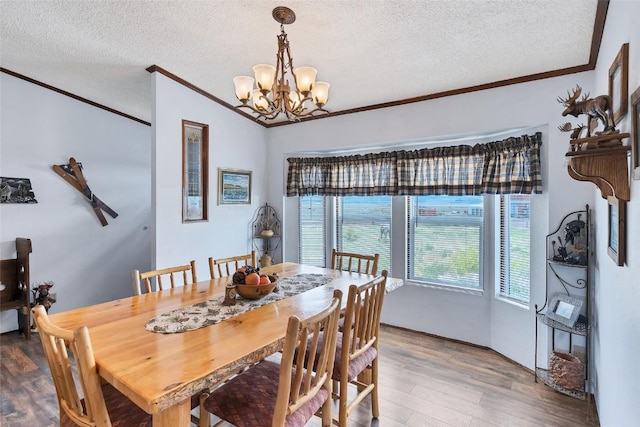 dining area featuring a textured ceiling, hardwood / wood-style flooring, and an inviting chandelier