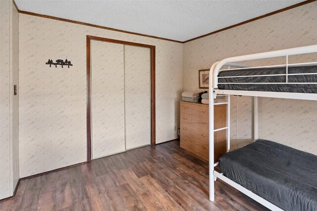 unfurnished bedroom featuring dark hardwood / wood-style floors, ornamental molding, and a textured ceiling