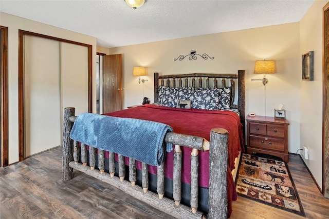 bedroom featuring a closet, dark hardwood / wood-style flooring, and a textured ceiling