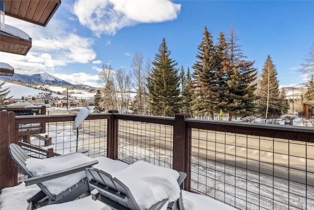 snow covered back of property with a mountain view