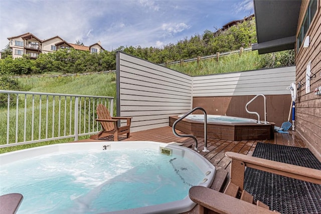 wooden deck featuring hot tub deck surround