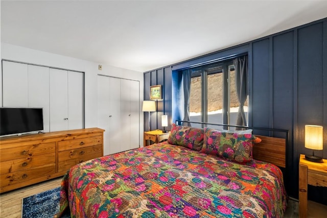 bedroom featuring multiple closets and wood finished floors