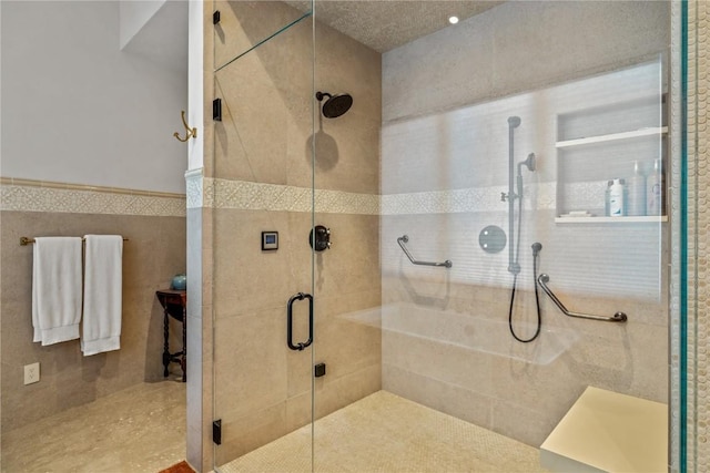 bathroom featuring tile walls and a shower with door