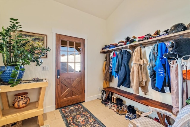 mudroom featuring vaulted ceiling and light tile patterned flooring